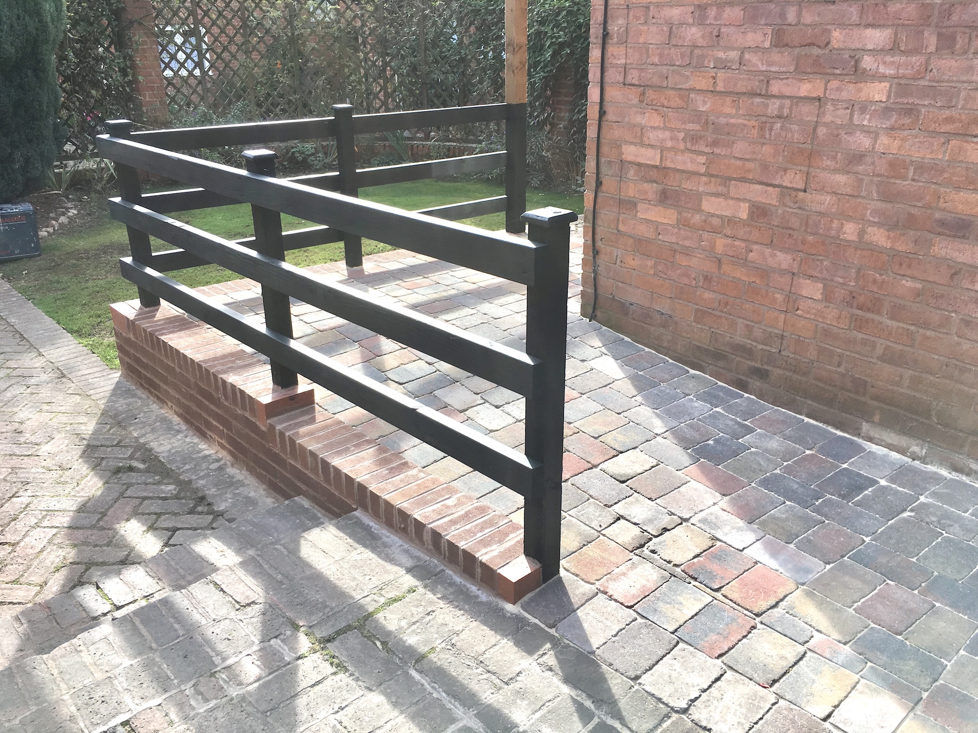 Block paved wheelchair ramp with handrails providing level access to a residential entrance in Alcester.